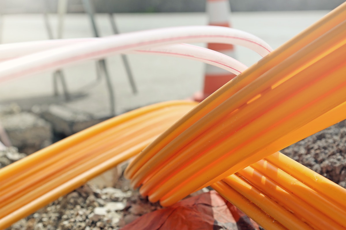 Orangefarbene Rohre für Glasfaserkabel im Straßenbau