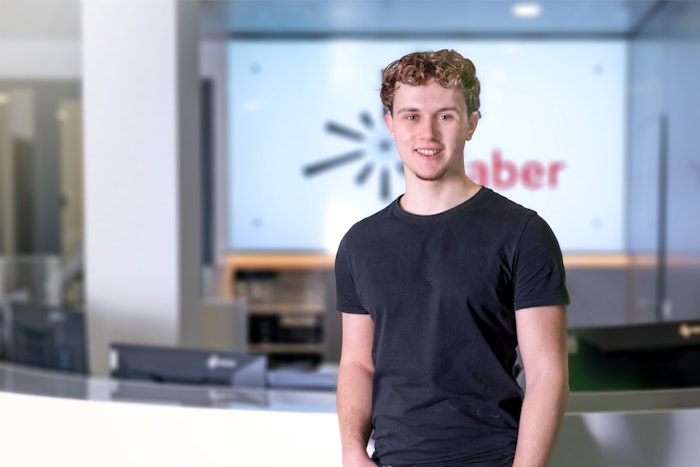 Junger Mann mit schwarzem T-Shirt und blonden Locken