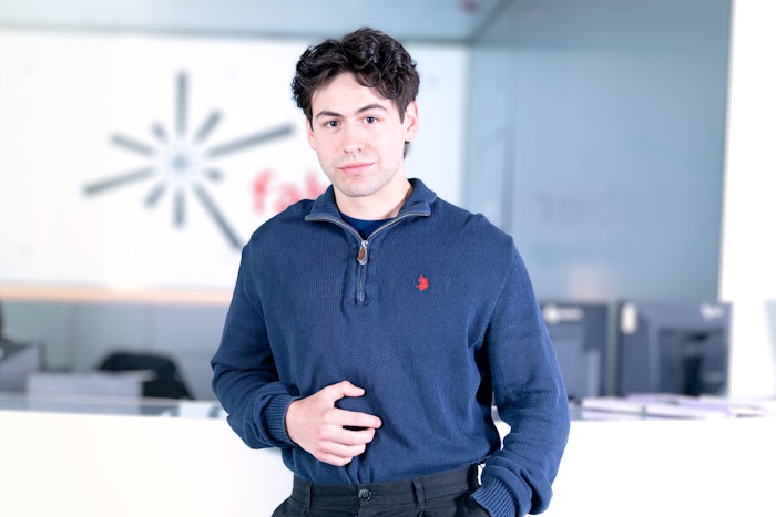 Junger Mann in blauem Pullover und schwarzen Haaren
