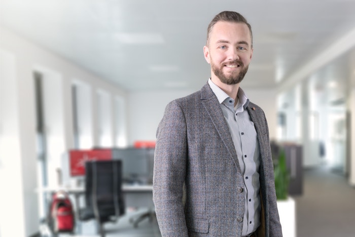 Mann mit Bart in gestreiftem Hemd und grauem Blazer